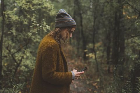 女子在秋季徒步旅行期间发短信照片