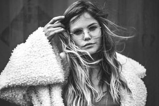 穿着羊皮大衣的女人的灰度照片