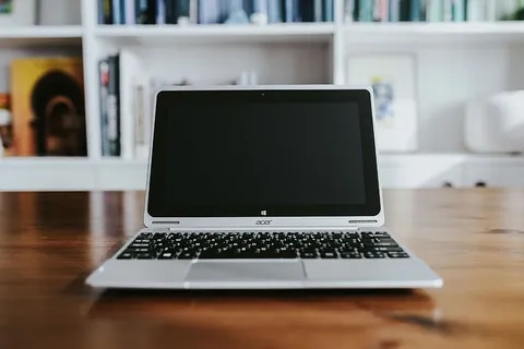 桌上放着各种物品的银色笔记本电脑 桌上放着各种物品的银色笔记本电脑