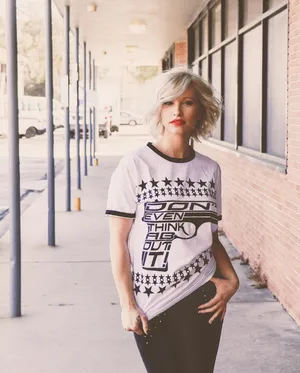 身穿黑白圆领T恤站在灰色地板上的女士