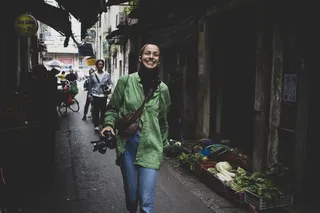 微笑的女人走在蔬菜旁边