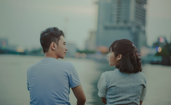 面对水体和建筑物的男人和女人