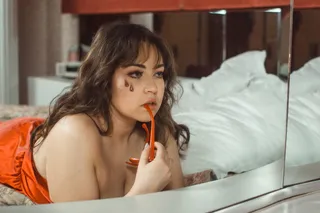 床上的女人靠着房间里的镜子