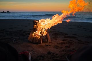 白天海边篝火的延时照片