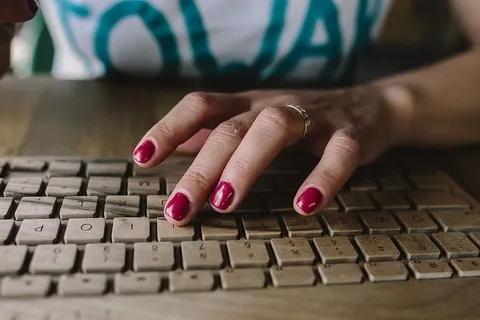 女性手在无线木质键盘上打字的特写 女性手在无线木质键盘上打字的特写