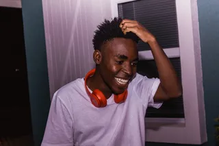 男子搔头大笑的照片