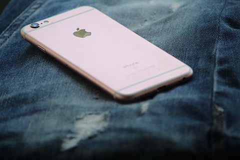 玫瑰金Iphone 6s在蓝色牛仔裤上的特写照片