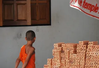 一个男孩走在一堵白色的墙上