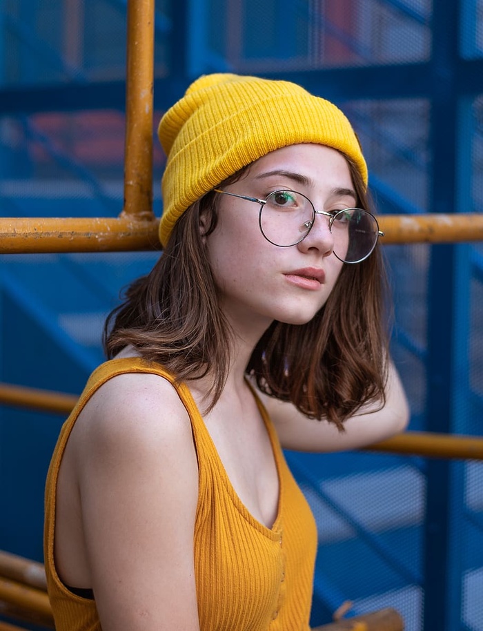 身穿黄色背心、针织帽和嬉皮士眼镜的女子