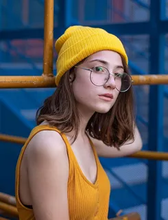 身穿黄色背心、针织帽和嬉皮士眼镜的女子