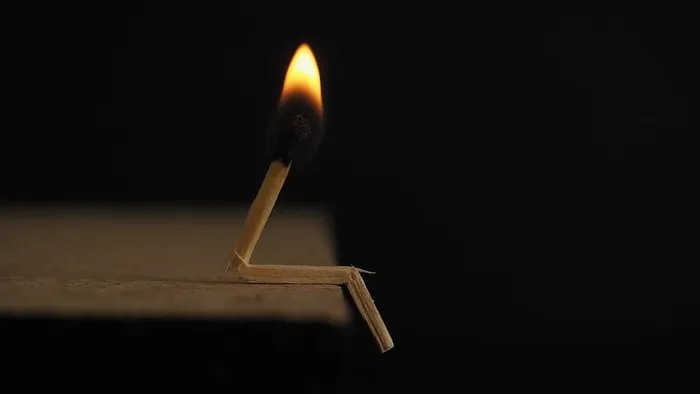 棕色木质表面上点燃的火柴棒