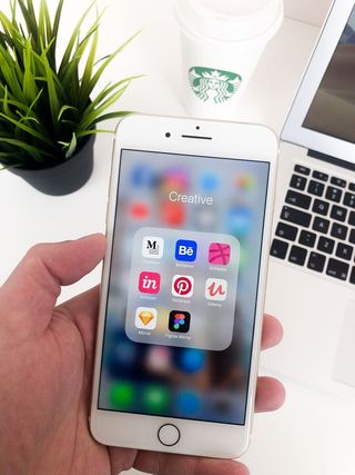 手持iPhone显示创意文件夹图标的人