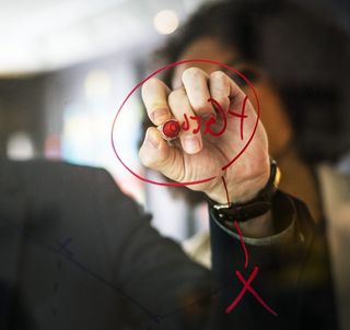 戴黑表的人用红笔在镜子上写字