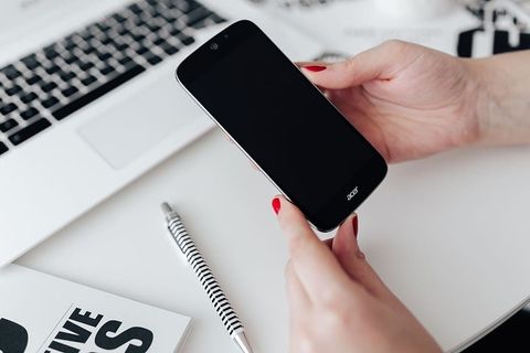 女商人在办公桌前使用手机