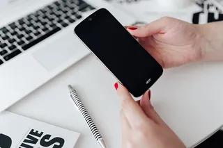 女商人在办公桌前使用手机