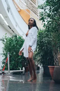身穿白色长袖衬衫的女子站在绿树旁 身穿白色长袖衬衫的女子站在绿树旁