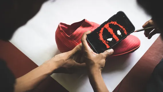 拿着带有死水坑墙纸的智能手机的人