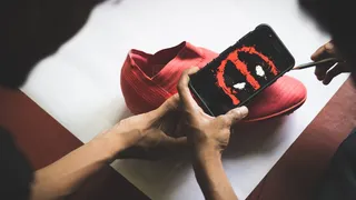 拿着带有死水坑墙纸的智能手机的人