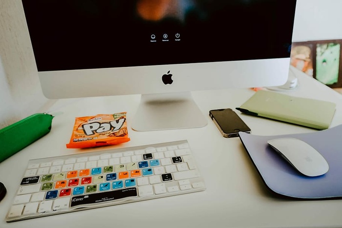 打开桌上的银色iMac、Apple Magic鼠标和Apple Magic键盘