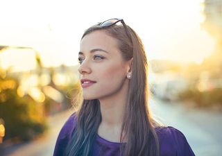 一位身穿紫蓝色连衣裙的金发女郎在户外摆姿势