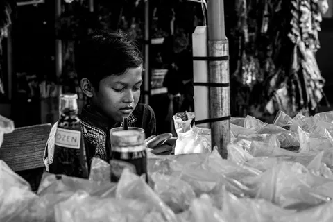 男孩坐在桌子旁向下看