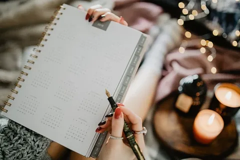 躺在床上的笔记本上写东西，里面有咖啡、蜡烛和姜饼