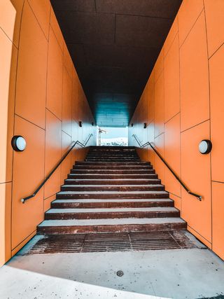 橙色墙旁的棕色楼梯