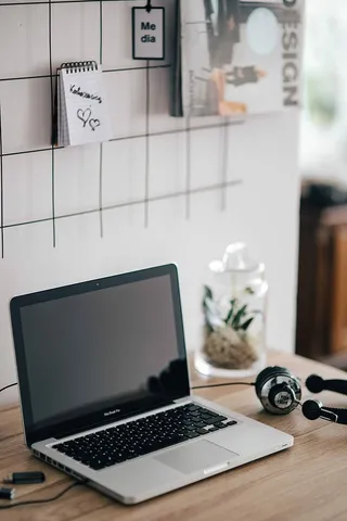 MacBook Pro在木制书桌上带耳机