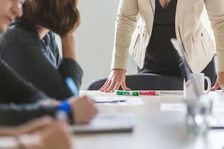 一个靠在桌子上的有权势的女人