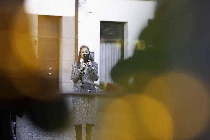 使用黑色智能手机对女性进行选择性聚焦拍摄