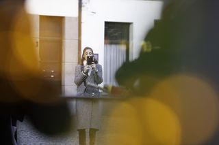 使用黑色智能手机对女性进行选择性聚焦拍摄