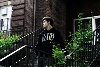 男子在砖房附近扶着楼梯栏杆