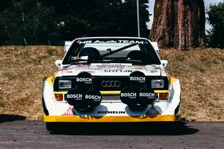 白色赛车停在绿树后面