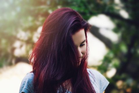 白天在绿叶树旁穿着灰色帽袖衬衫的女士 白天在绿叶树旁穿着灰色帽袖衬衫的女士