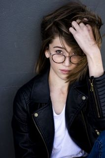 斜靠在灰墙前的女人