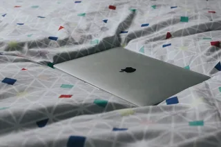 银色MacBook，搭配各色纺织品