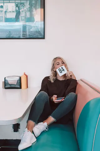 坐在白色桌子旁边沙发上的女人