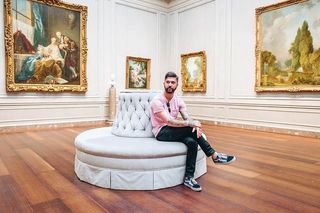 坐在艺术室内白色沙发上的男人