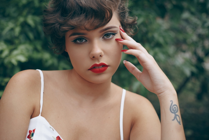 穿着意大利面系带连衣裙、涂着红色口红和红色指甲油的女人