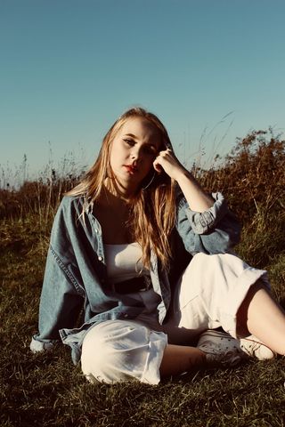 女子坐在草地上的照片