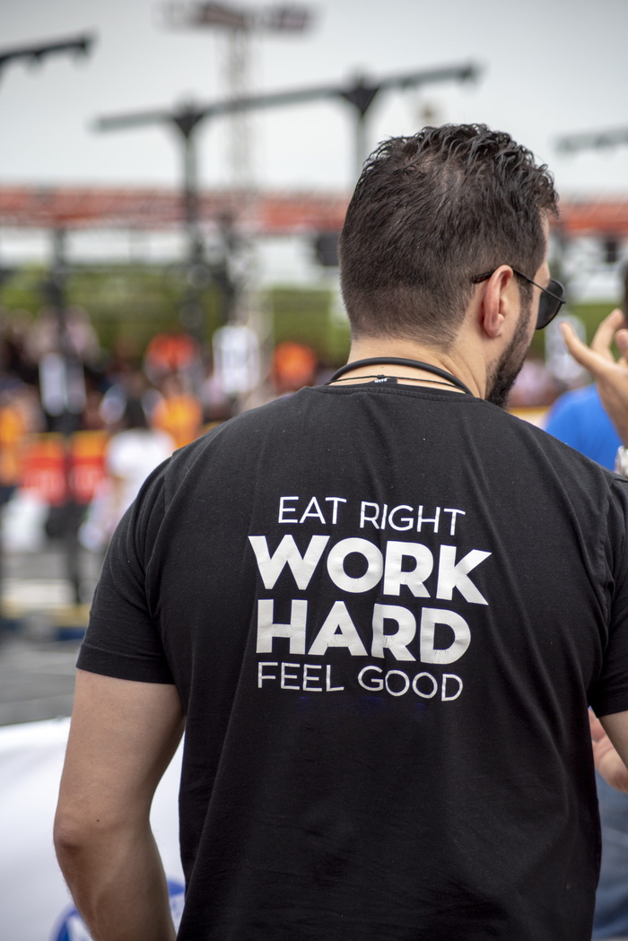 穿着Eat Right Work Hard Feel Good印花衬衫的人