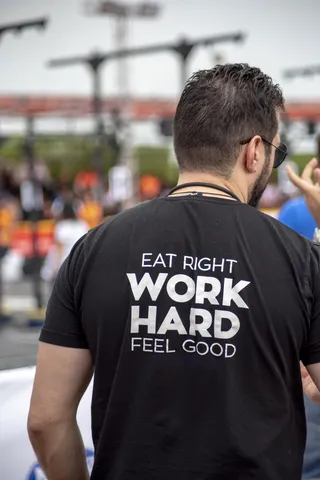 穿着Eat Right Work Hard Feel Good印花衬衫的人