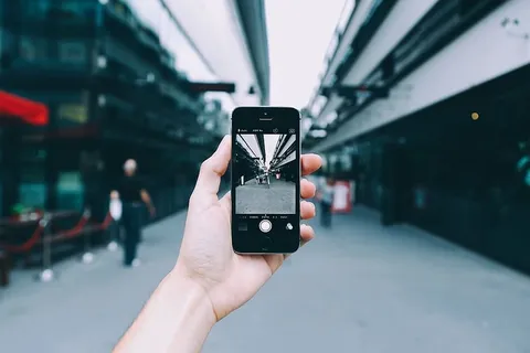 拿着灰色Iphone 5s的人 拿着灰色Iphone 5s的人