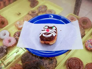 蓝色盘子上放着一个有猫脸的甜甜圈。