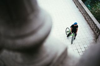 一位戴着蓝色帽子的年轻白人男性自行车手在街上停了下来