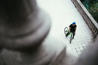 一位戴着蓝色帽子的年轻白人男性自行车手在街上停了下来