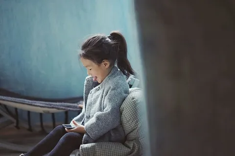 女孩在使用手机时伸出舌头 女孩在使用手机时伸出舌头