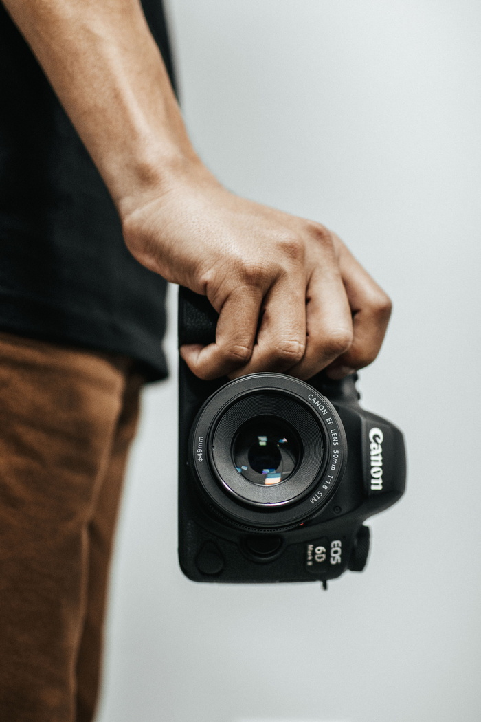 拿着黑色佳能Eos 6d单反相机的人