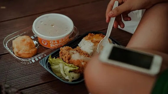 拿着白色一次性勺子吃炸鸡的人 拿着白色一次性勺子吃炸鸡的人