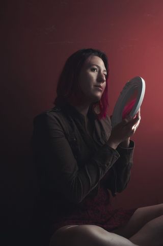 一名女子举着白色镜框的圆镜